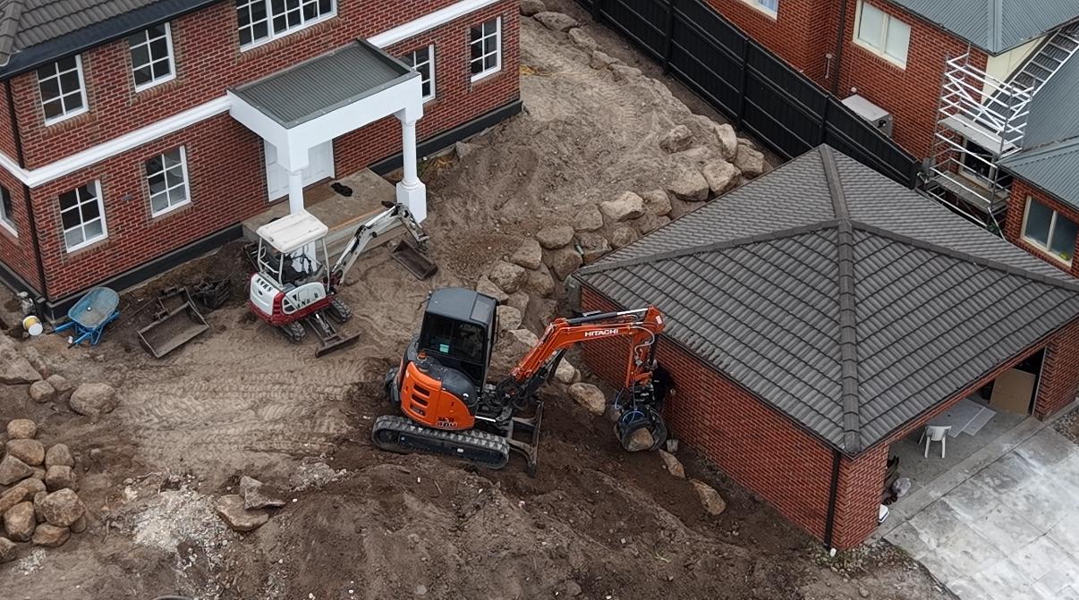 Twin excavators shaping the Sunbury estate site during earthworks