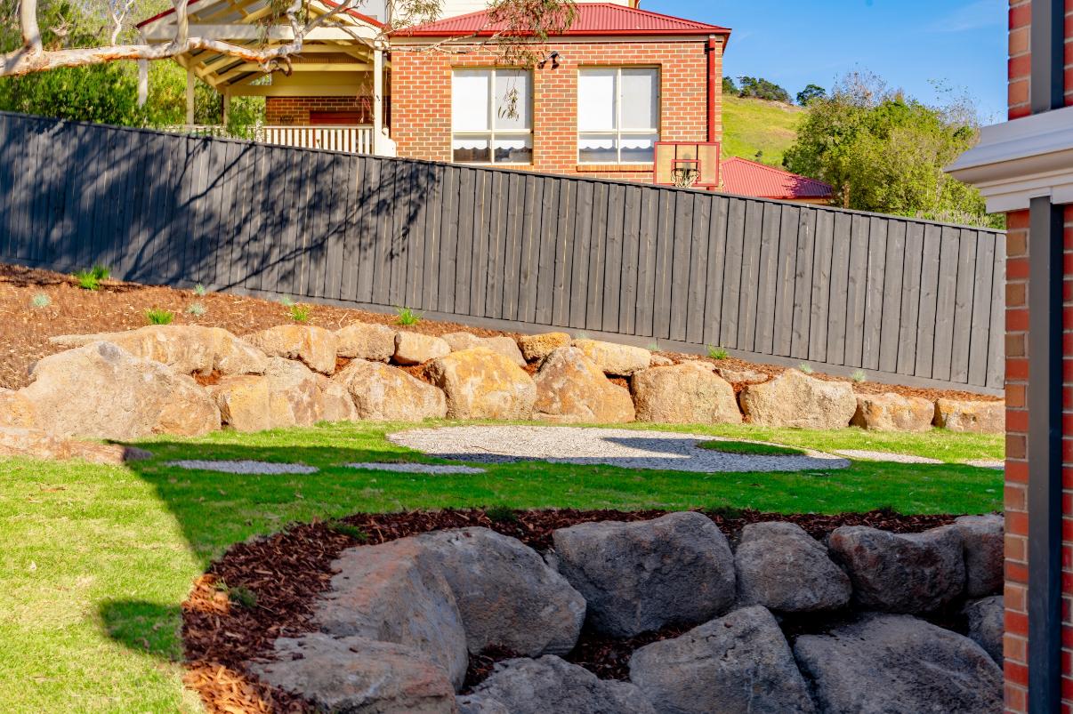 Boulder retaining wall and lawn at the rear of the estate