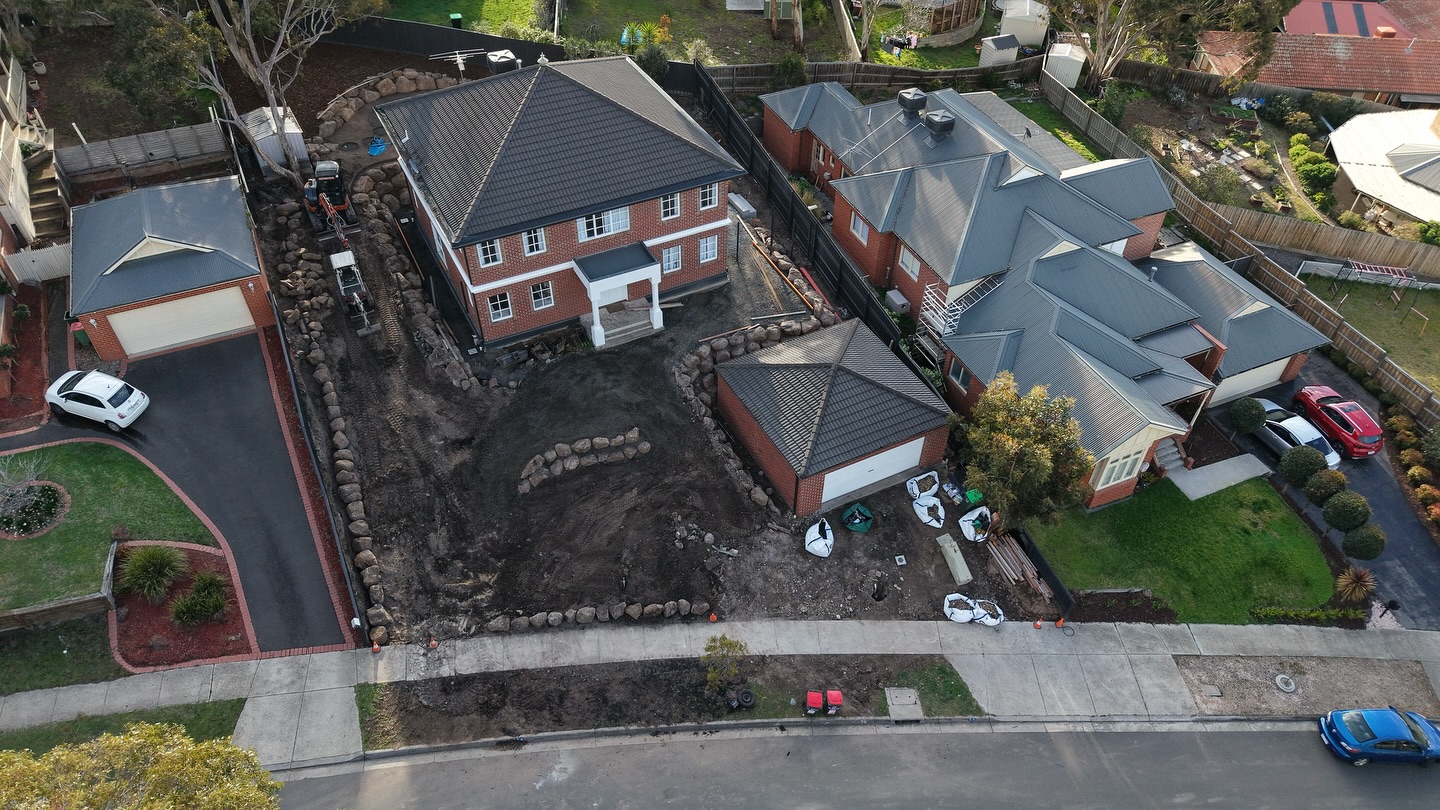 Aerial view of a site mid-build with retaining walls and earthworks underway